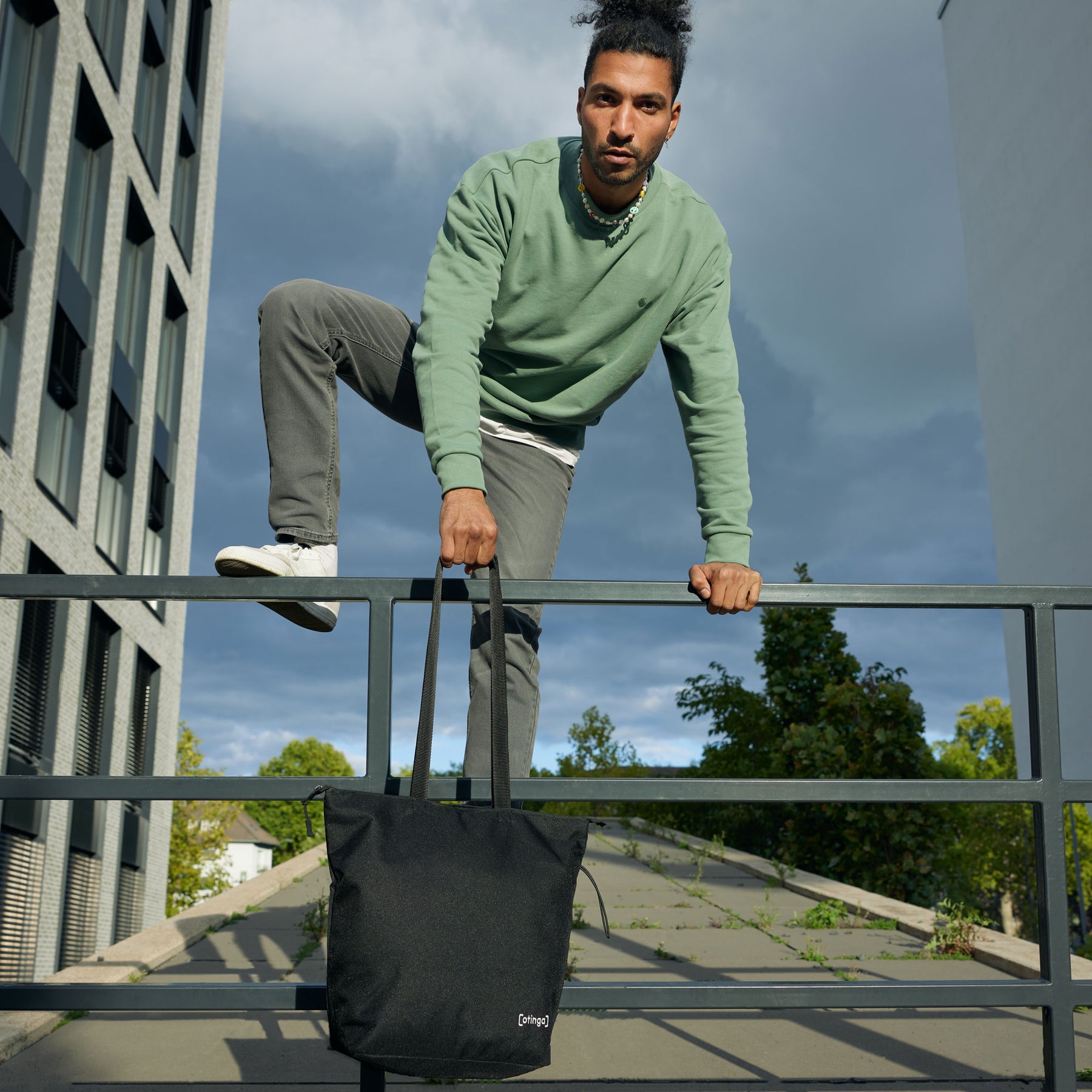 Mann trägt Fahrradtasche an Geländer